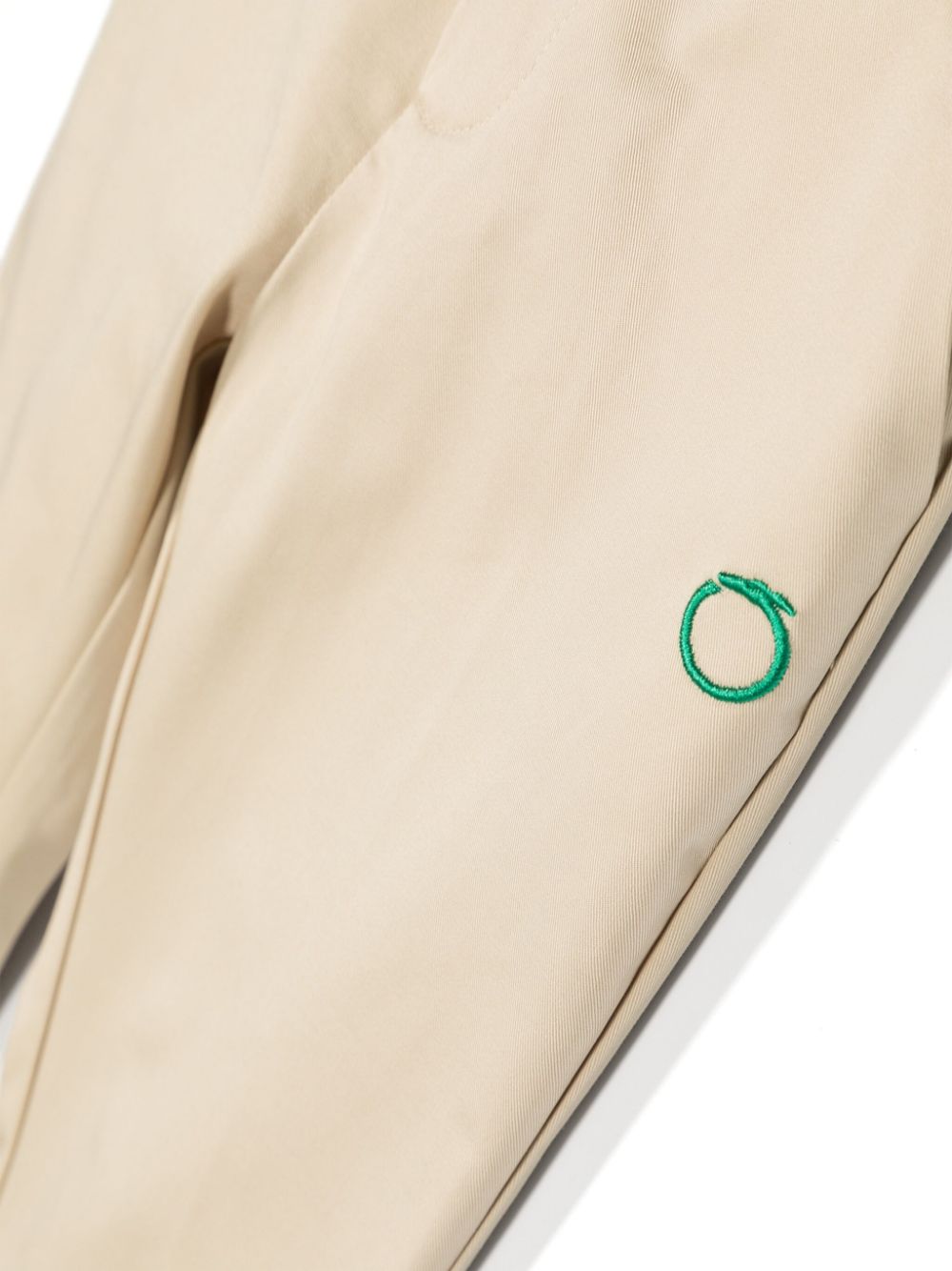 Beige baby trousers with green logo