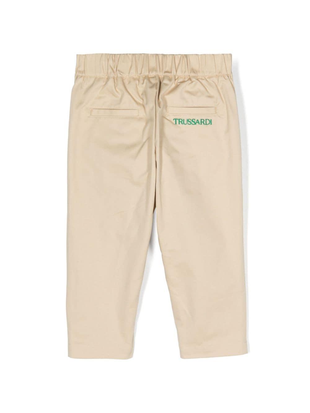 Beige baby trousers with green logo